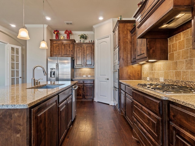 kitchen with light stone counters, custom exhaust hood, stainless steel appliances, dark wood-type flooring, and an island with sink