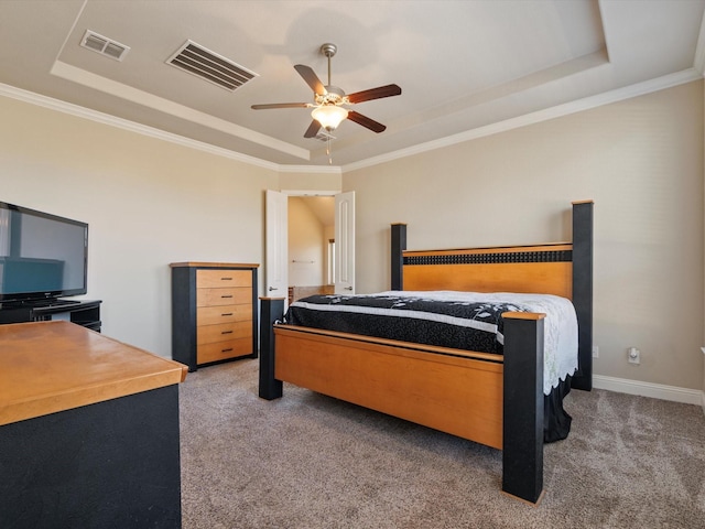 carpeted bedroom featuring ceiling fan, a raised ceiling, and crown molding