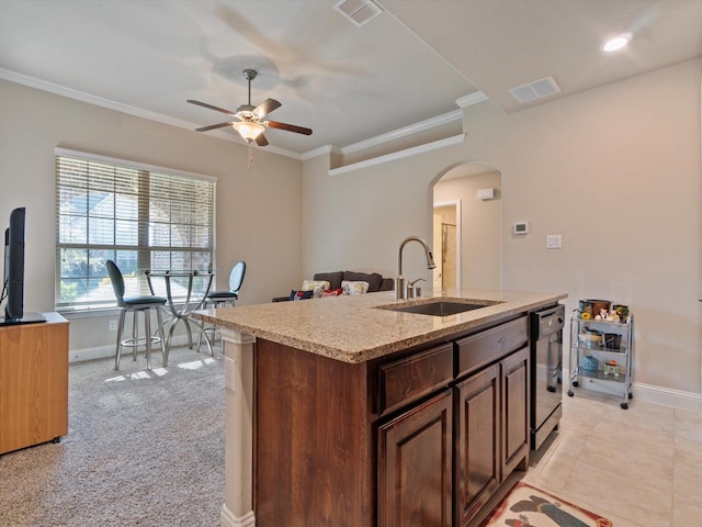 kitchen with light carpet, ceiling fan, a kitchen island with sink, sink, and black dishwasher