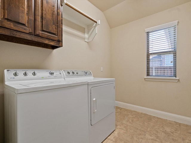 clothes washing area featuring cabinets, separate washer and dryer, and light tile patterned floors