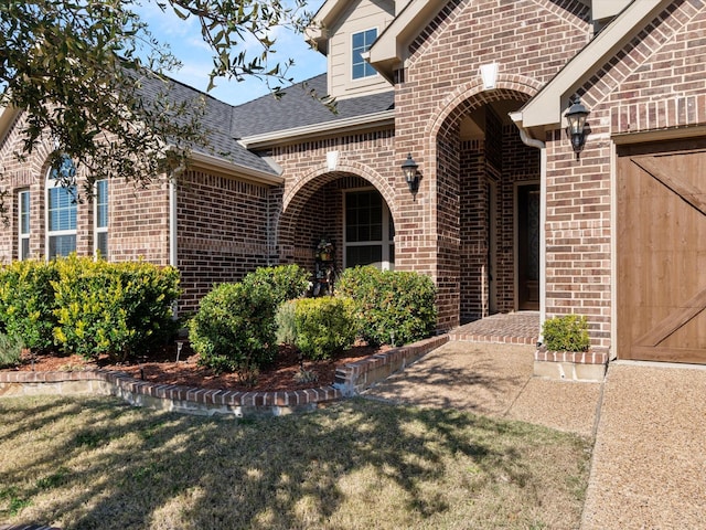 view of exterior entry featuring a yard