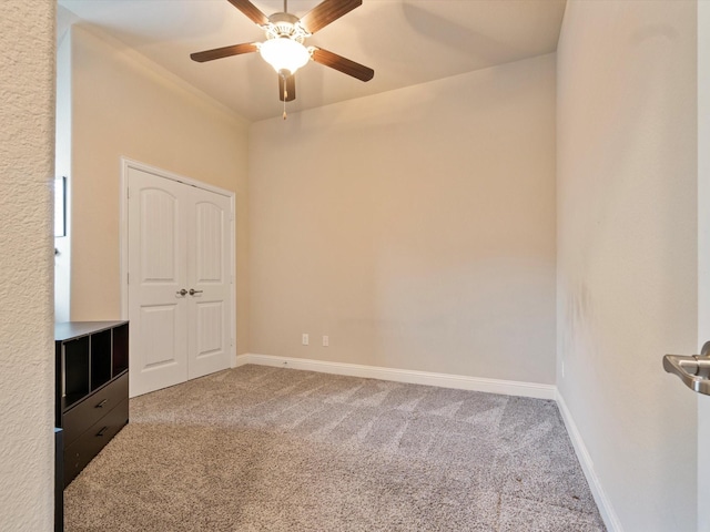 carpeted spare room featuring ceiling fan