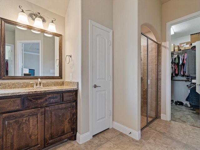 bathroom with tile patterned flooring, vanity, and a shower with door