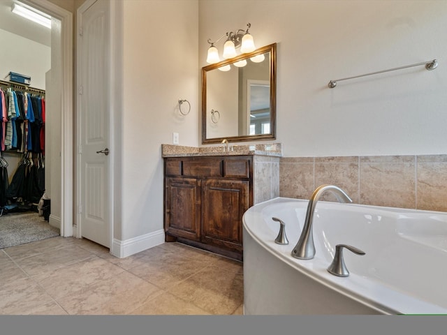 bathroom with tile patterned flooring, vanity, and a tub