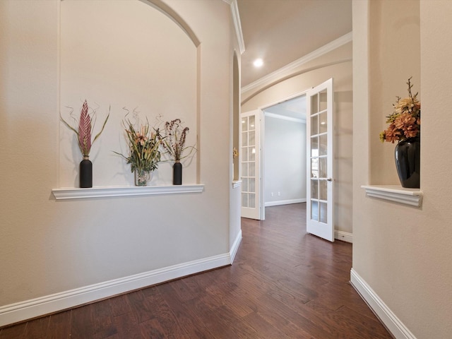 corridor featuring french doors, ornamental molding, and dark wood-type flooring