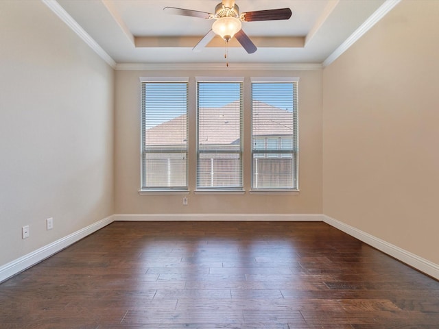 empty room featuring ceiling fan, ornamental molding, dark wood-type flooring, and a tray ceiling