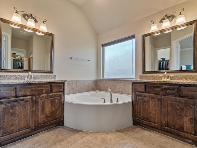 bathroom with tile patterned floors, vanity, and vaulted ceiling