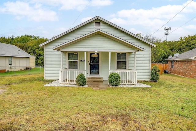 bungalow-style home featuring a porch, central air condition unit, and a front lawn