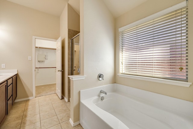 bathroom featuring plus walk in shower, vanity, and tile patterned floors