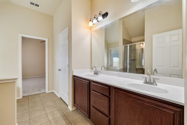 bathroom with tile patterned flooring, vanity, walk in shower, and vaulted ceiling