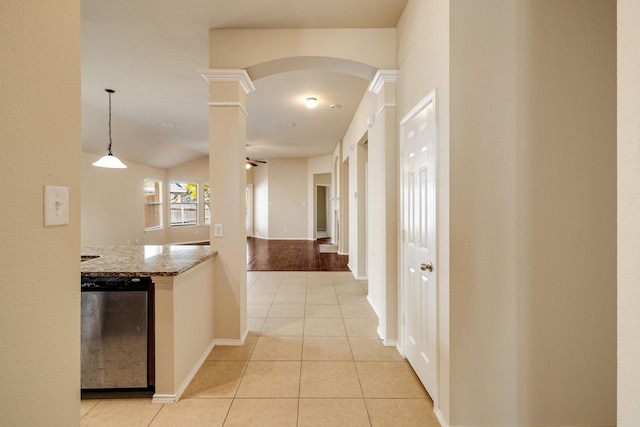 hallway with decorative columns and light tile patterned flooring