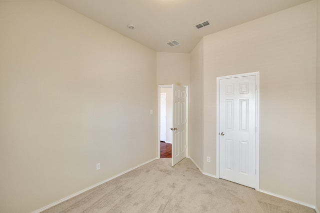 carpeted spare room featuring lofted ceiling