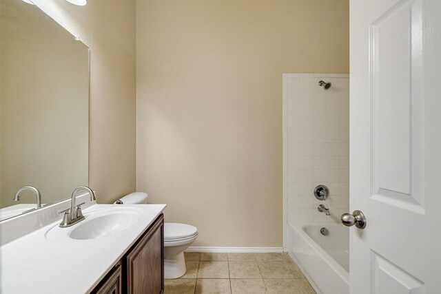 full bathroom featuring tiled shower / bath, tile patterned flooring, vanity, and toilet