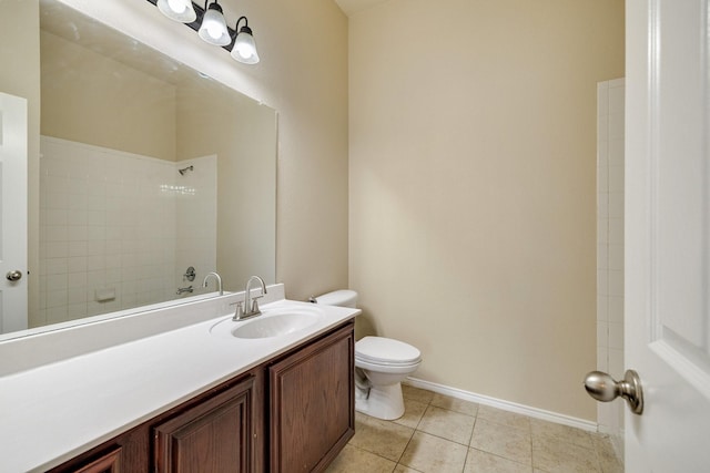 bathroom with toilet, a tile shower, vanity, and tile patterned floors