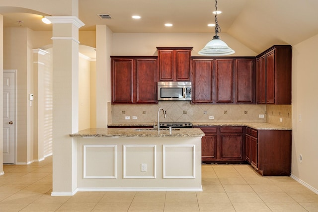 kitchen with decorative backsplash, light stone counters, sink, and decorative columns