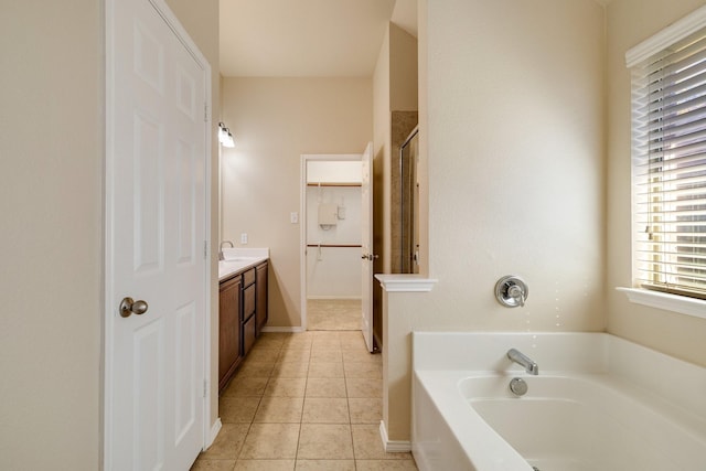 bathroom with tile patterned floors, a bathtub, and vanity