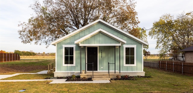 view of front of home featuring an outbuilding and a front lawn