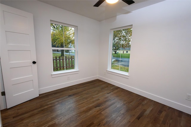 empty room featuring a wealth of natural light, ceiling fan, and dark hardwood / wood-style floors