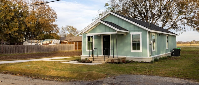 view of front of home with central air condition unit and a front lawn