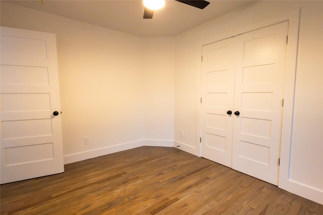 unfurnished bedroom featuring a closet, dark hardwood / wood-style floors, and ceiling fan