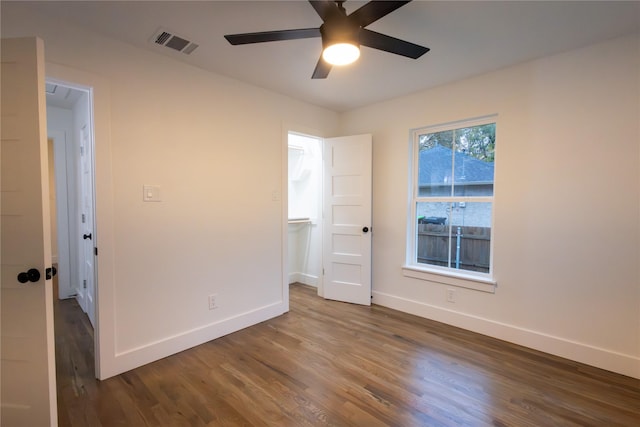 empty room with ceiling fan and dark hardwood / wood-style floors