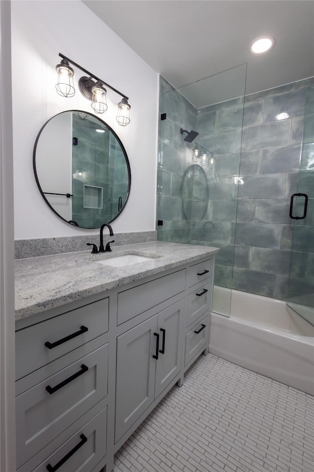 bathroom featuring tile patterned flooring, vanity, and combined bath / shower with glass door