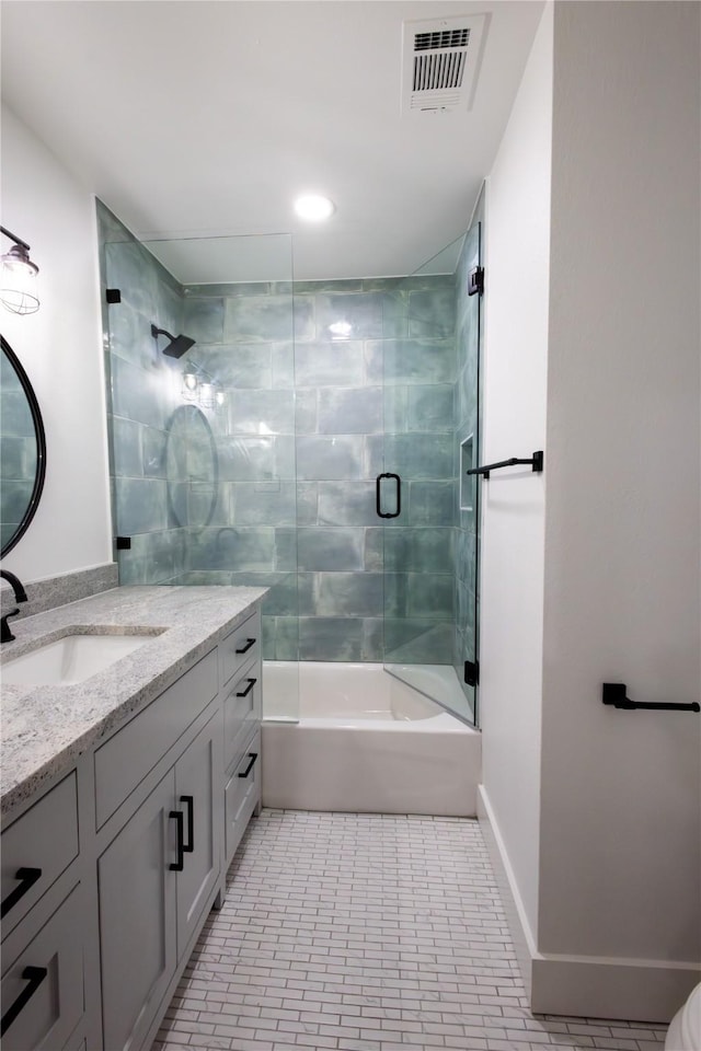 bathroom featuring tile patterned flooring, vanity, and bath / shower combo with glass door