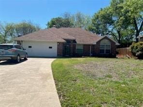 ranch-style house with a garage and a front lawn