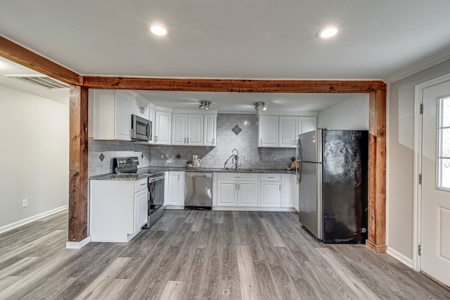 kitchen featuring white cabinetry, light stone counters, light hardwood / wood-style flooring, crown molding, and appliances with stainless steel finishes