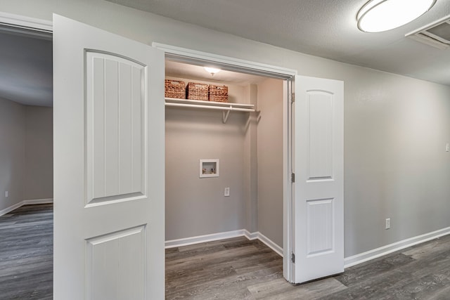 washroom featuring dark hardwood / wood-style floors, a textured ceiling, and hookup for a washing machine