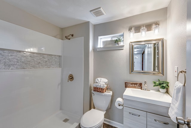 bathroom with a shower, vanity, and toilet