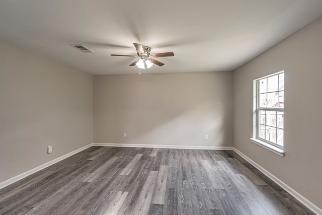 empty room with dark hardwood / wood-style flooring and ceiling fan