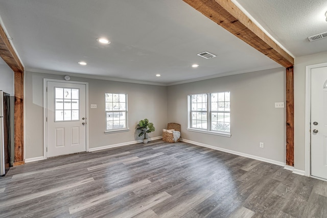 entryway with beam ceiling, hardwood / wood-style floors, and ornamental molding