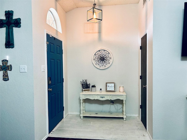 entrance foyer with vaulted ceiling and light wood-type flooring