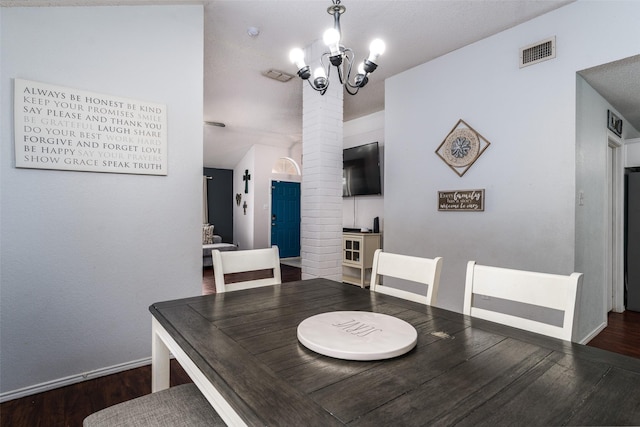 dining space featuring dark hardwood / wood-style floors and a chandelier