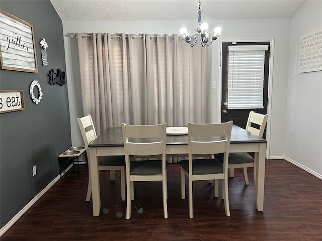 dining space with a textured ceiling, dark hardwood / wood-style floors, and an inviting chandelier