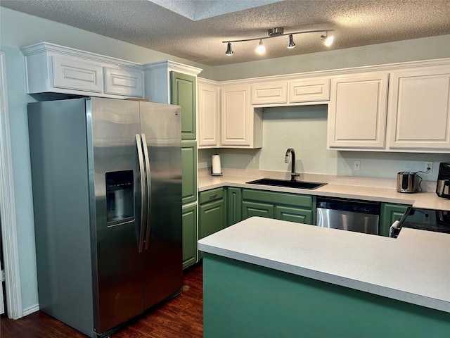 kitchen with dark hardwood / wood-style flooring, sink, white cabinets, and stainless steel appliances