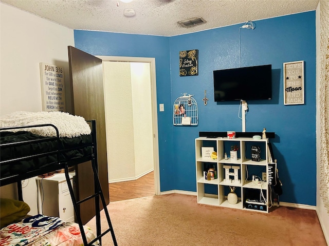 carpeted bedroom featuring a textured ceiling