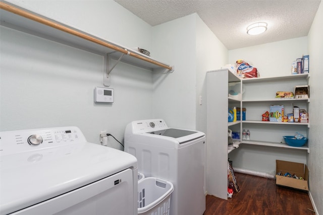 washroom featuring dark hardwood / wood-style flooring, washer and dryer, and a textured ceiling