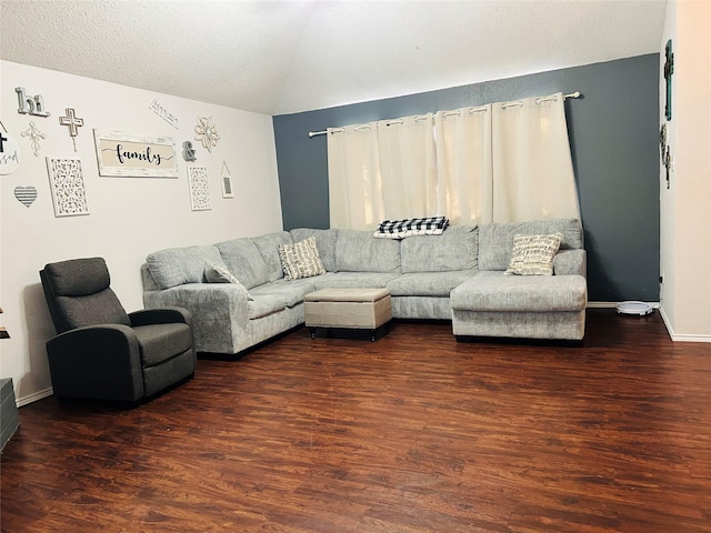 living room with a textured ceiling and dark wood-type flooring