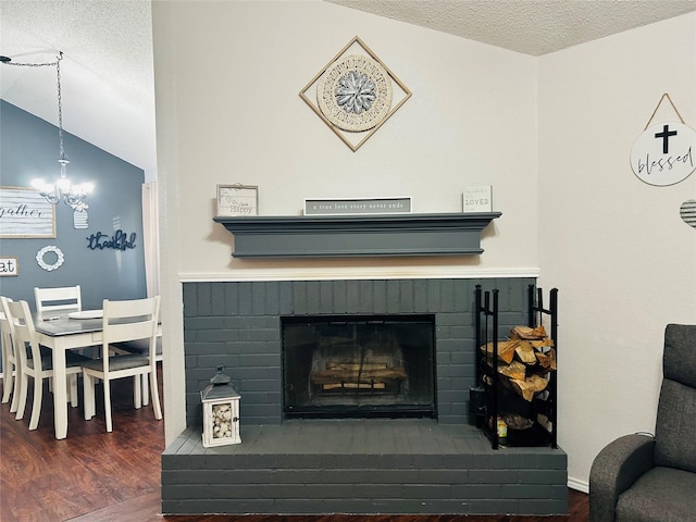 interior space featuring hardwood / wood-style floors, a notable chandelier, a fireplace, and a textured ceiling