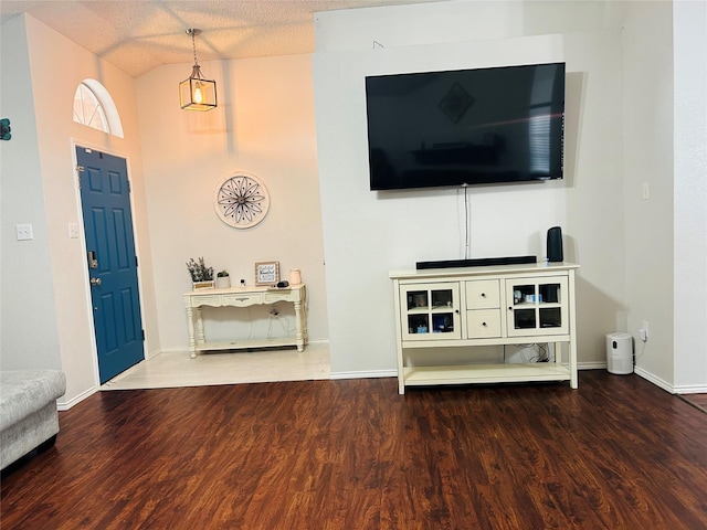 foyer with wood-type flooring, a textured ceiling, and lofted ceiling