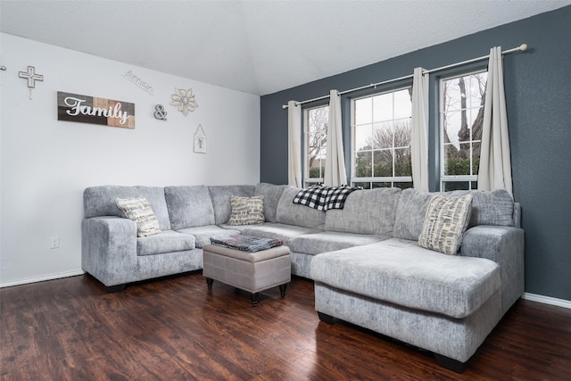 living room with lofted ceiling, a healthy amount of sunlight, dark hardwood / wood-style flooring, and a textured ceiling