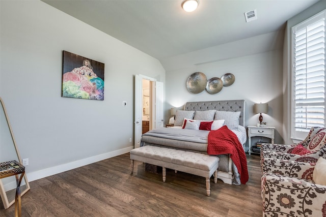 bedroom with ensuite bath, dark wood-type flooring, and vaulted ceiling