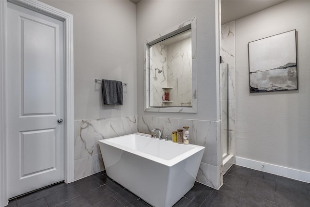 bathroom with shower with separate bathtub, tile patterned floors, and tile walls