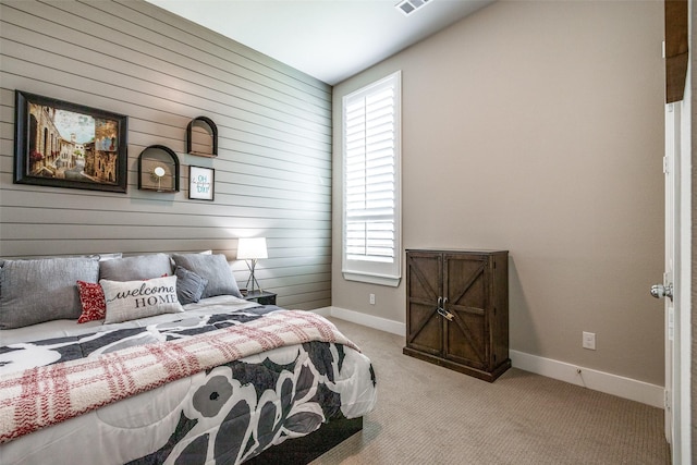 carpeted bedroom with wood walls