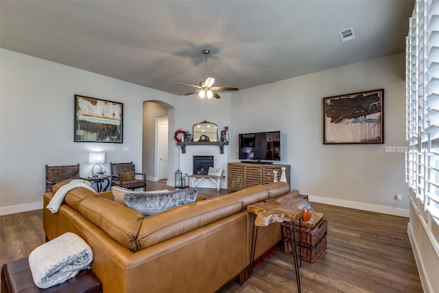 living room featuring ceiling fan and dark hardwood / wood-style floors