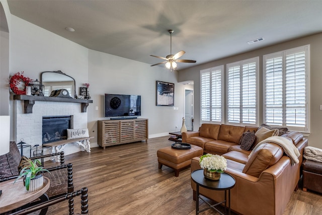 living room with hardwood / wood-style flooring, ceiling fan, and a fireplace