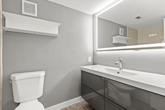 bathroom featuring toilet, vanity, and hardwood / wood-style flooring