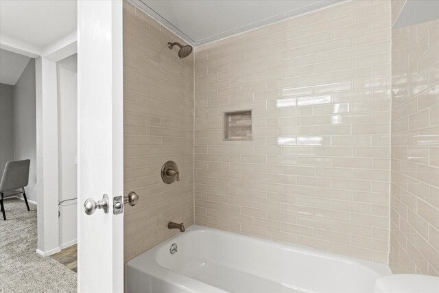 bathroom with hardwood / wood-style flooring and tiled shower / bath